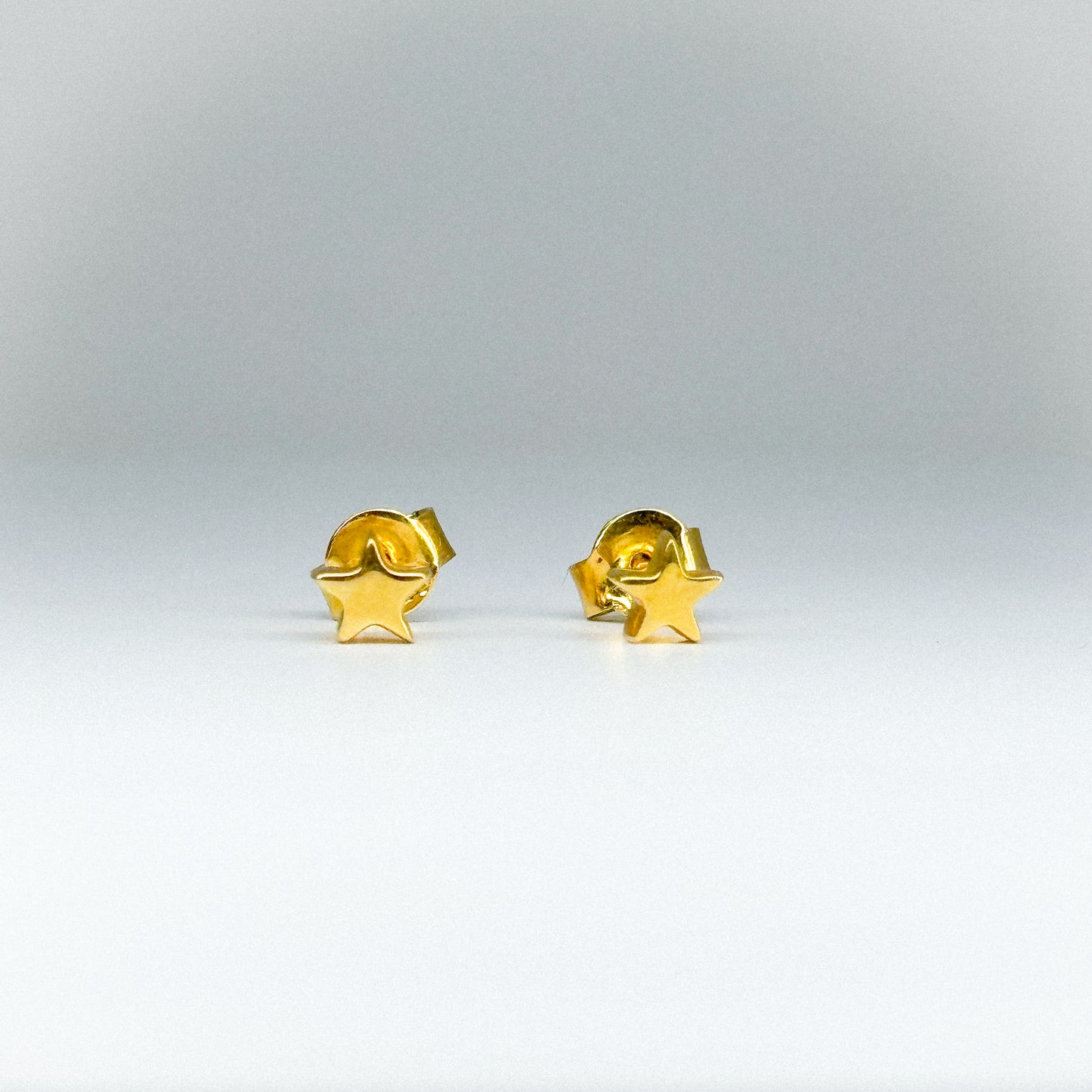 Aretes estrella en oro 18k