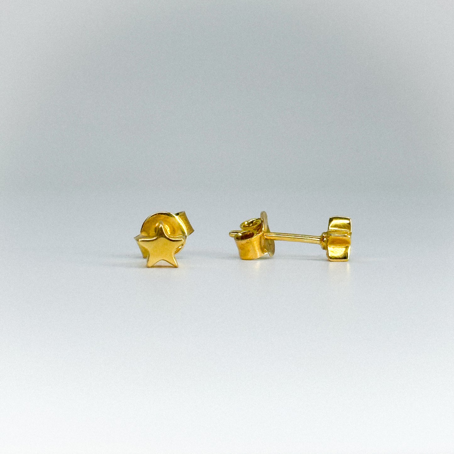 Aretes estrella en oro 18k