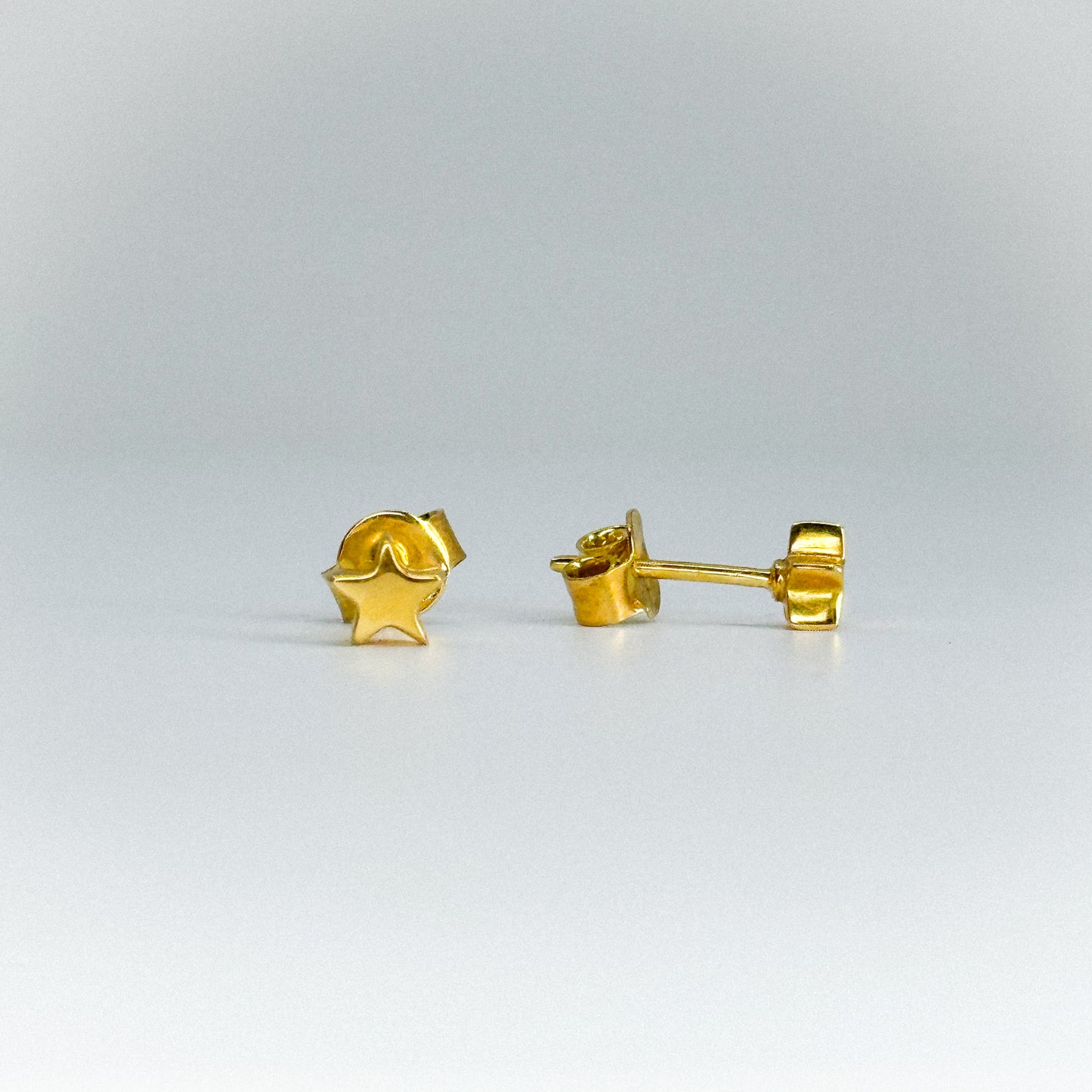 Aretes estrella en oro 18k